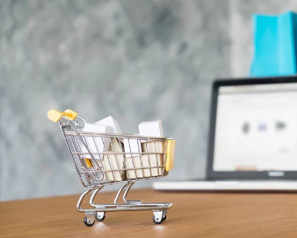 Mini shopping cart beside a laptop